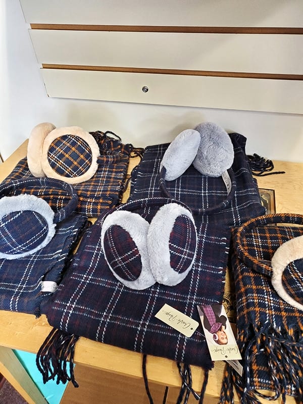 A display of flannel scarves and matching blue faux fur earmuffs