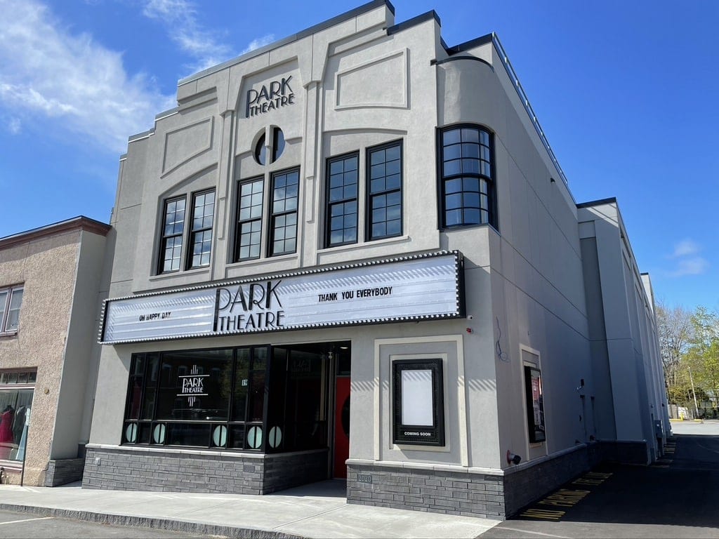 The front of a recently built movie theatre with a white marquee and name of Park Theatre in retro lettering
