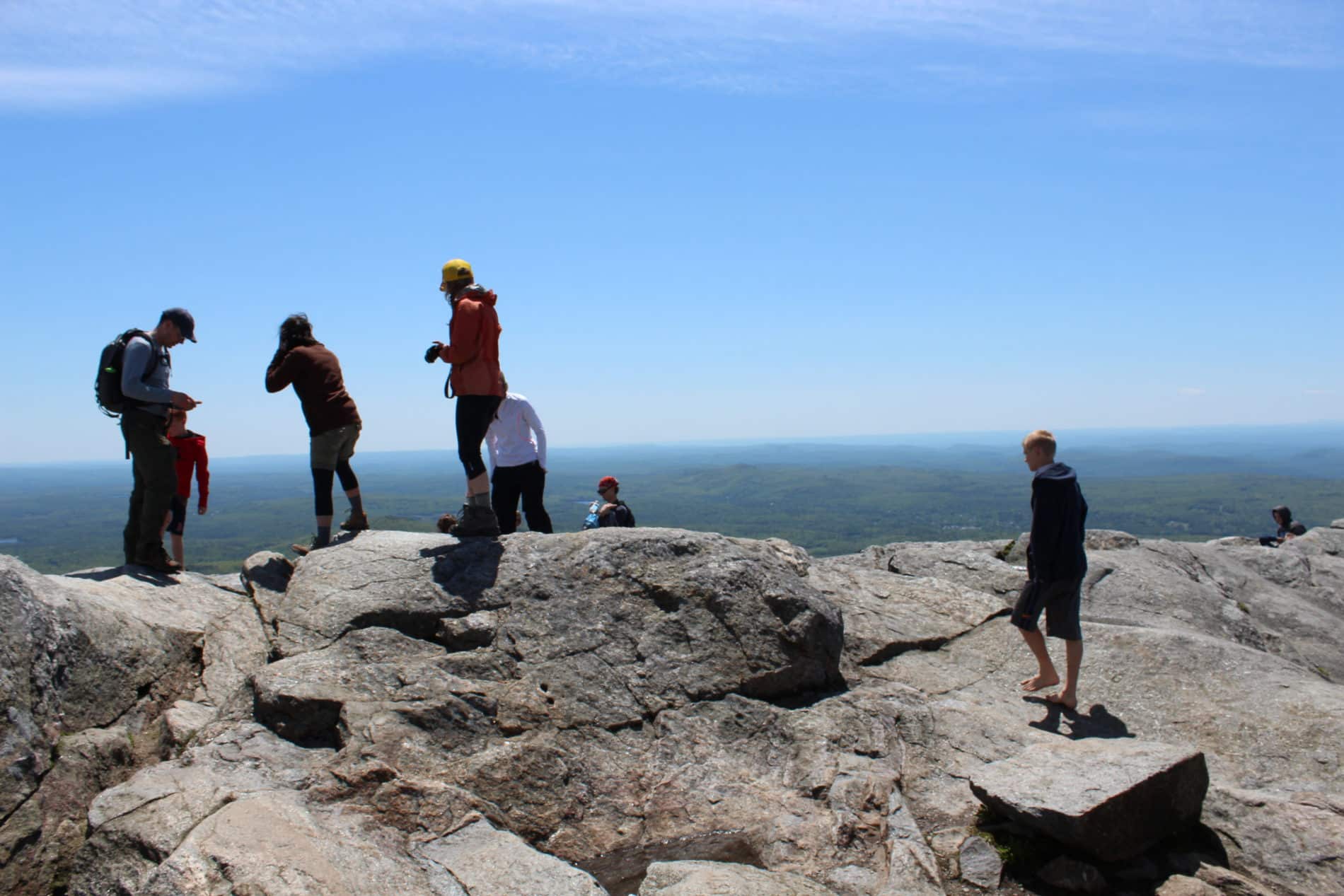 Hikers on the summit of Mount Monadnock overlooking the valley