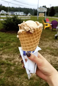 Ice cream in a waffle cone held up with sign behind it