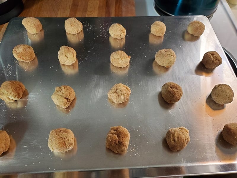 rolled cookie dough balls arranged on a pan
