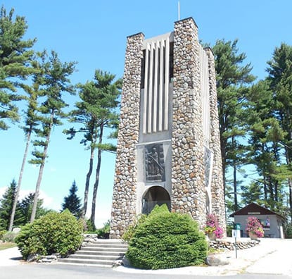 A stone tower surrounded by pine trees 