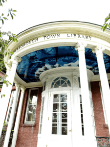 domed entrance into a brick library with blue mural on the ceiling