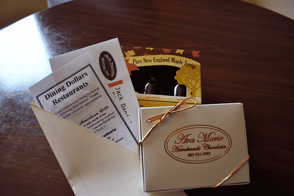 A box of chocolates, syrup samples and dining vouchers sit atop one another, then placed on a table