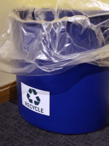 Blue bin with recycle sticker on it.