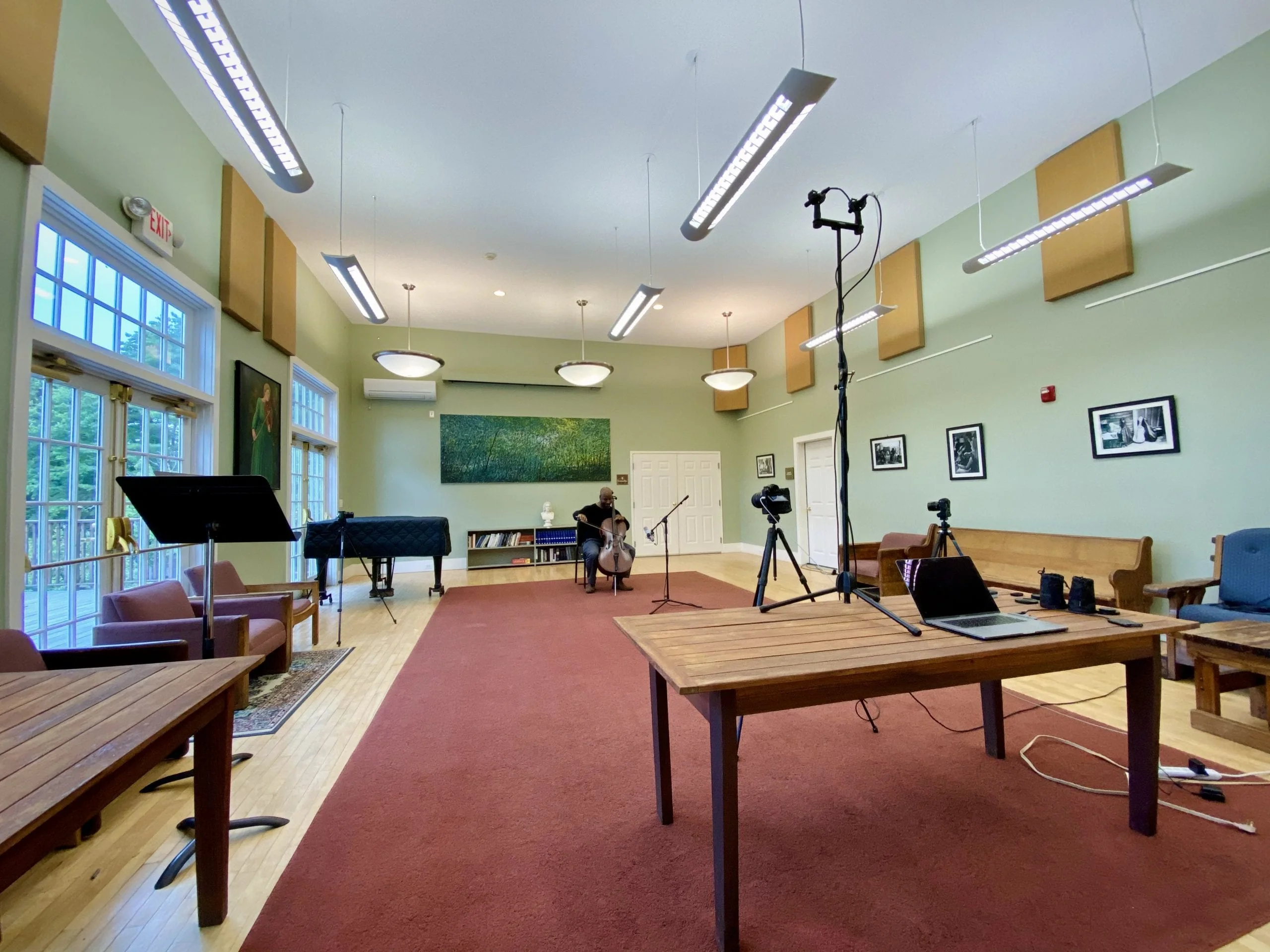A room with recording devices focus on a musician playing a cello.