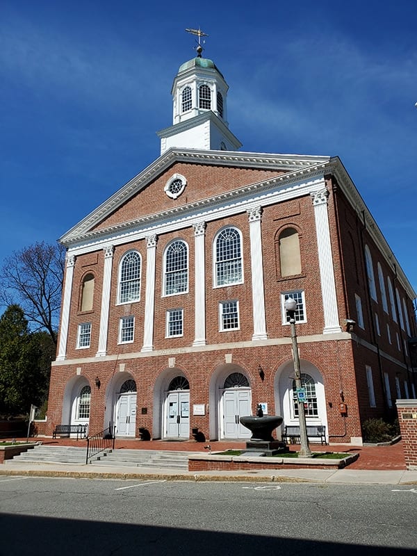 Brick building with a bell tower serves as the town hall.