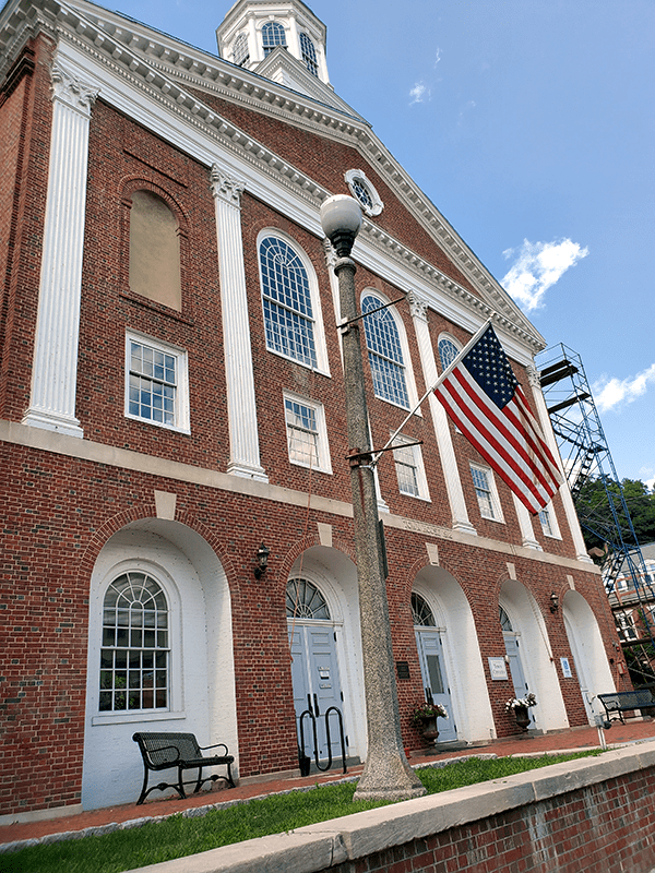 brick and column town hallwith flag on a sunny day